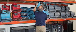 Water and Mold Damage Restoration Technician Prepping Air Movers For Flooding Repair Job